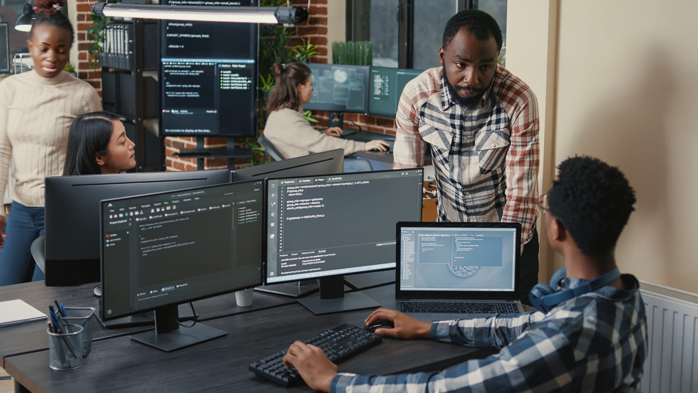Two developers reviewing an AI project on multiple screens.